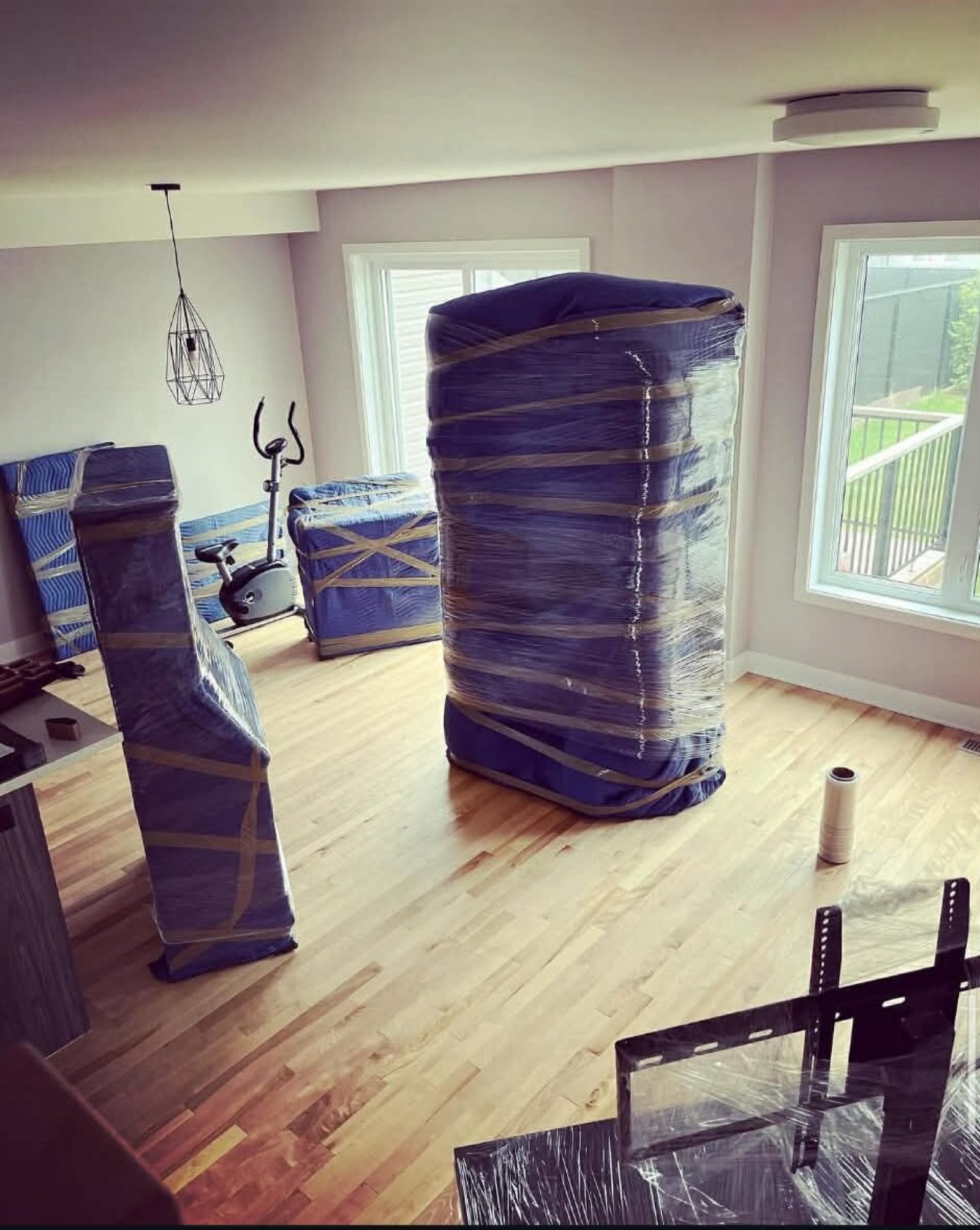 Meubles entièrement couverts dans un salon avec plancher de bois.
